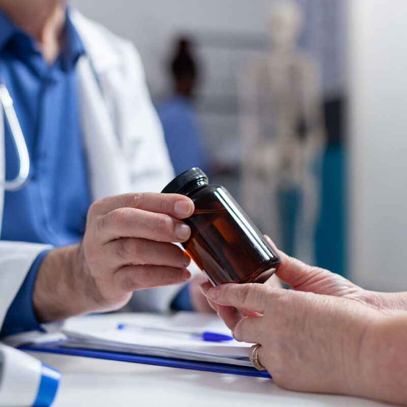 Doctor reviewing medications with a patient as part of simplifying health plans.