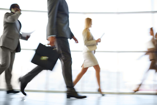 Business professionals walking quickly, symbolizing the need for healthcare for busy professionals.